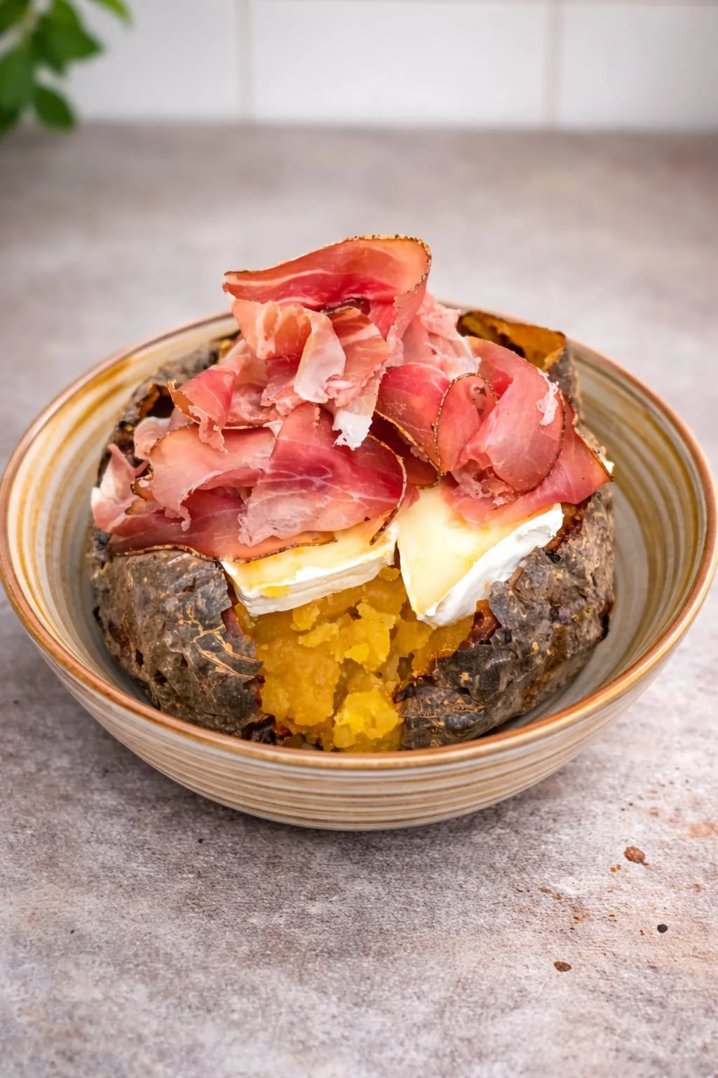 Patata gourmet farcita con speck, brie e crema di zucca, specialità della piola Va Bin Potato a Torino