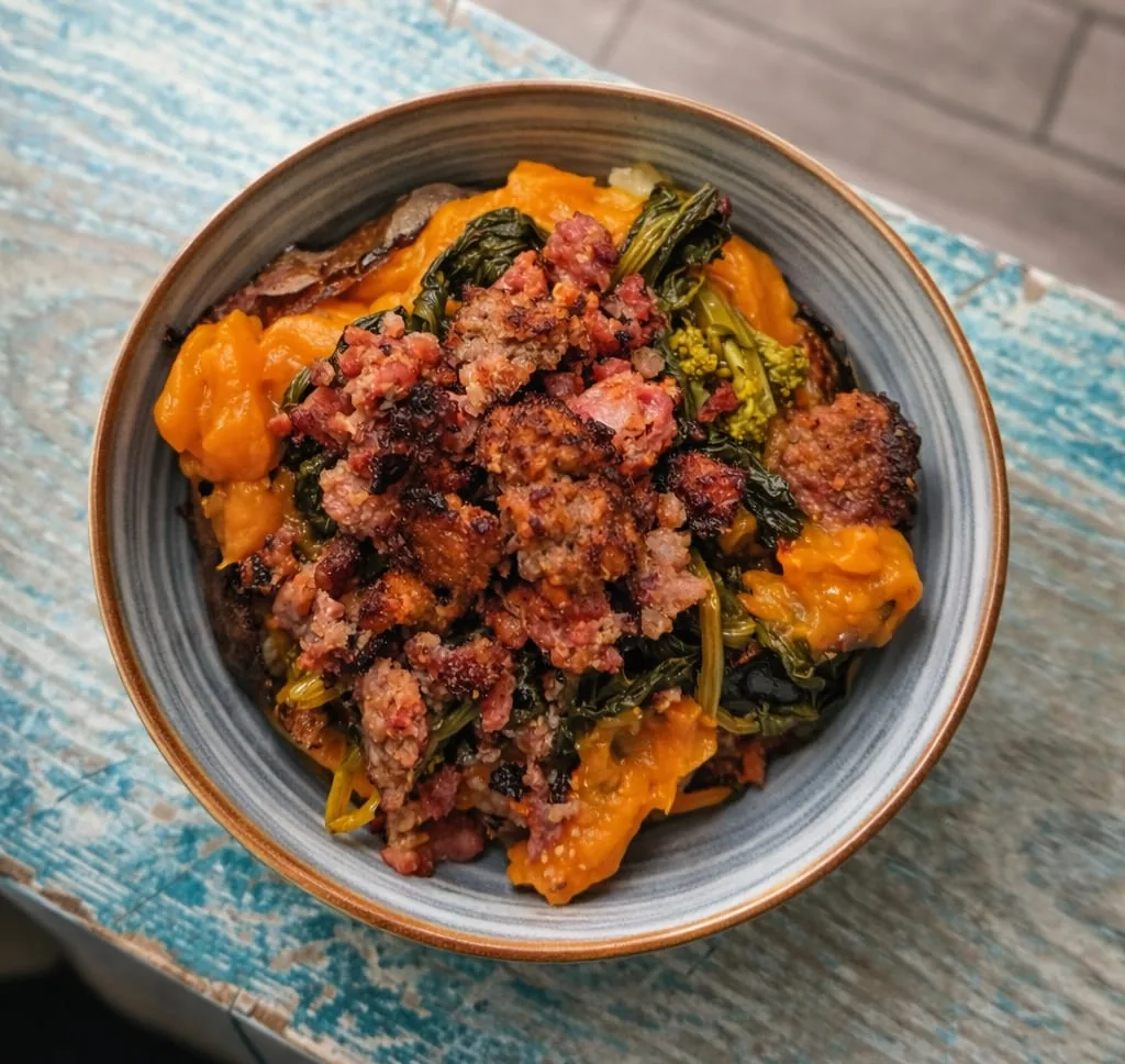 Patata ripiena di crema di zucca, cime di rapa saltate e salsiccia aromatizzata