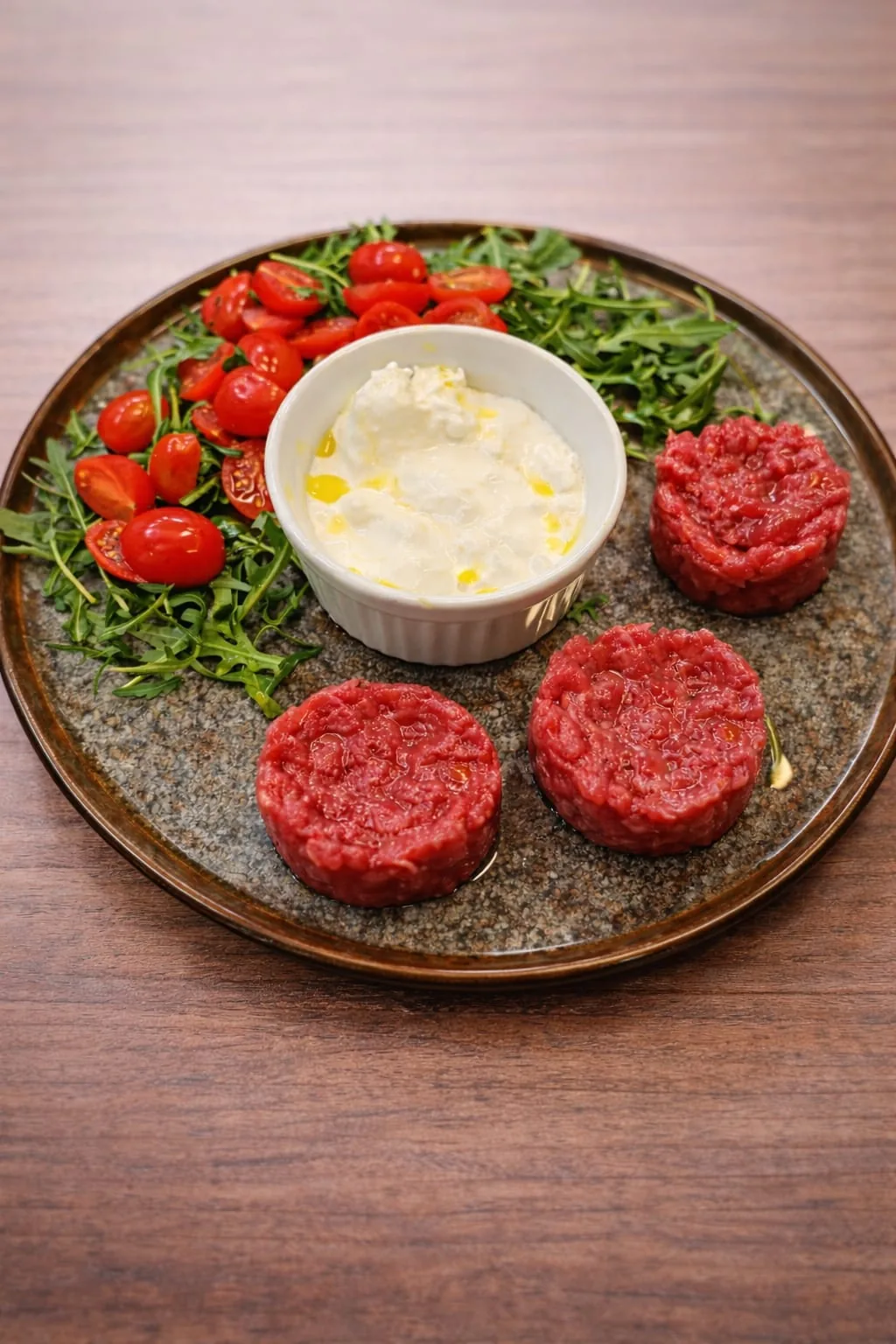 Tartare di fassona piemontese con stracciatella di burrata, pomodorini confit e rucola fresca