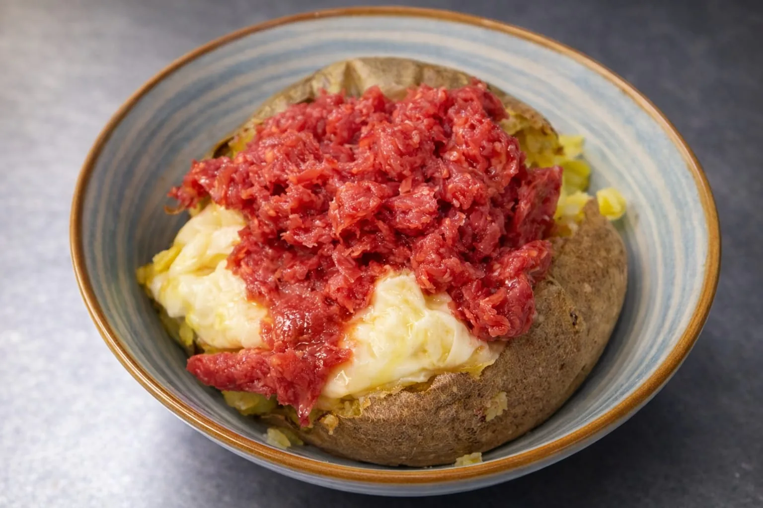 Patata gourmet con fonduta cremosa di formaggio e salsiccia di Bra in crosta dorata